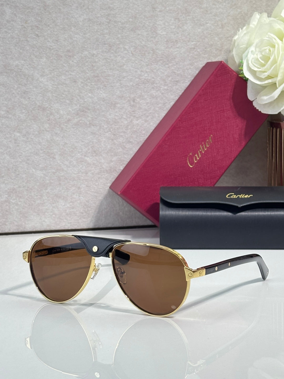 Cartier oval sunglasses with brown lenses and gold-tone frame, clear temple tips