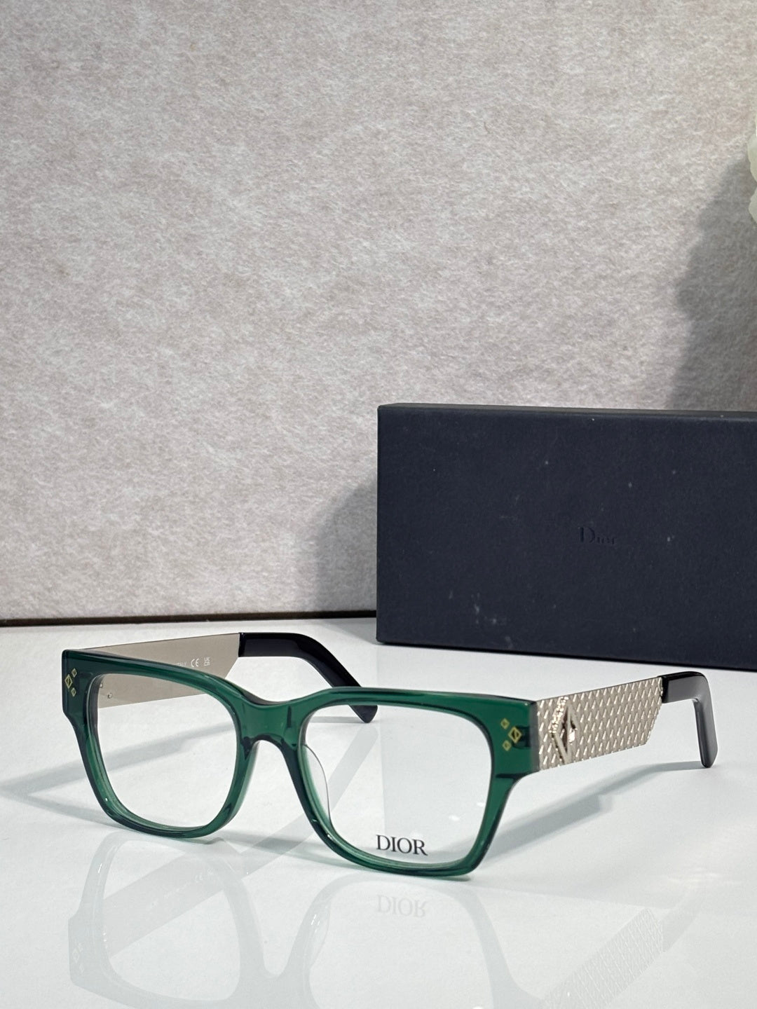 Dior eyeglasses with green frames and textured gold temple with Dior logo
