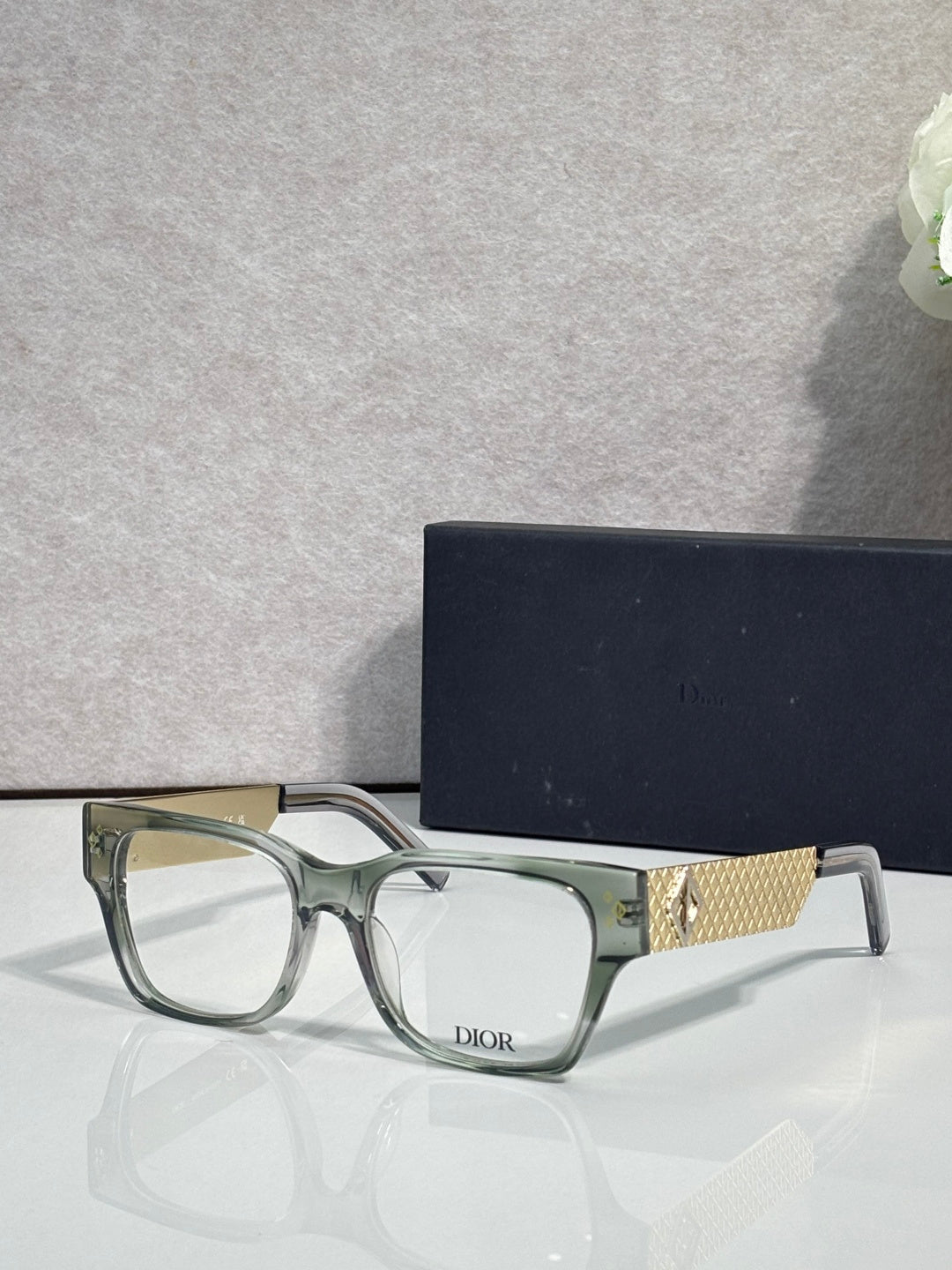 Dior eyeglasses with clear green frames and textured gold temple detail