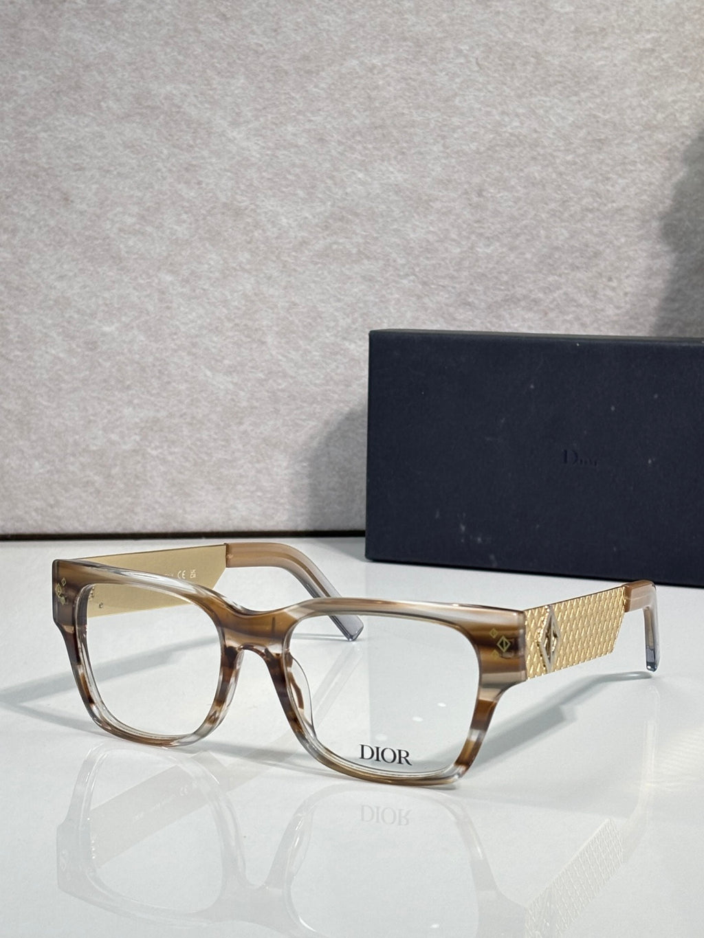 Dior eyeglasses with clear tan frames and textured gold temple with Dior logo