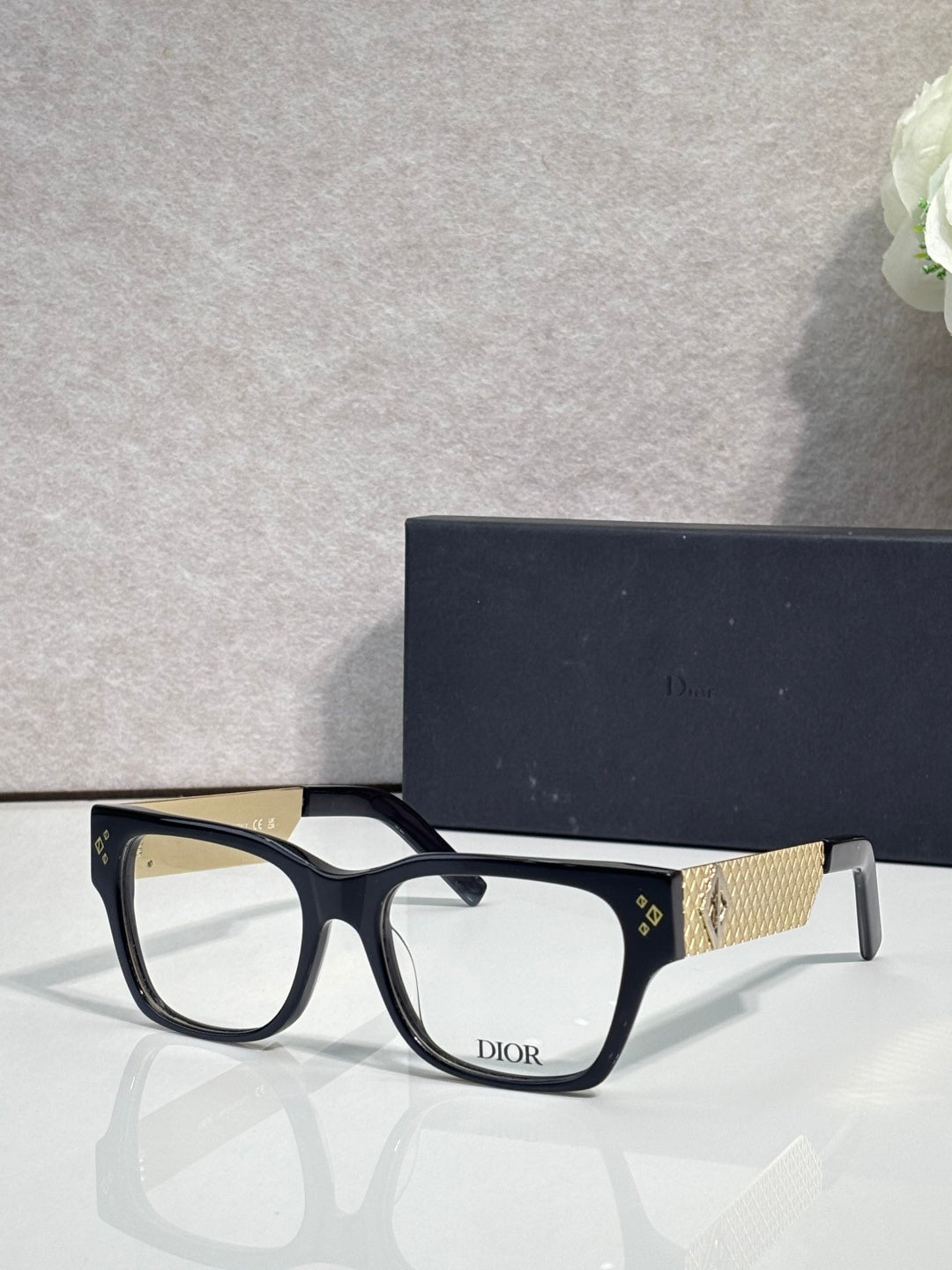 Dior eyeglasses with dark frames and textured gold temple bar with Dior logo