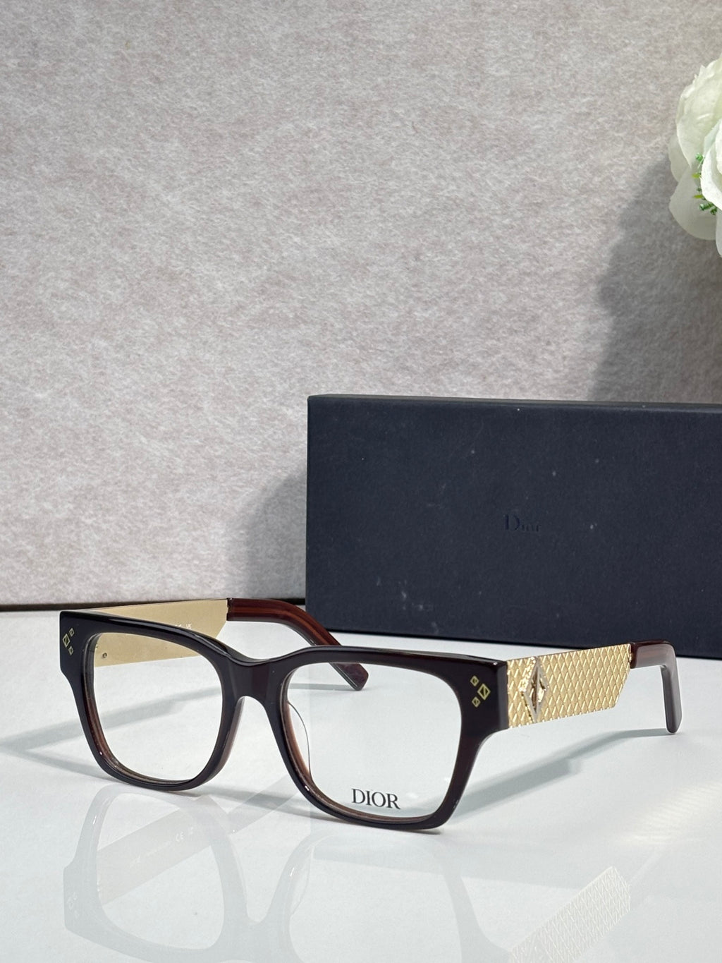 Dior eyeglasses with dark frames and textured gold temple with Dior logo