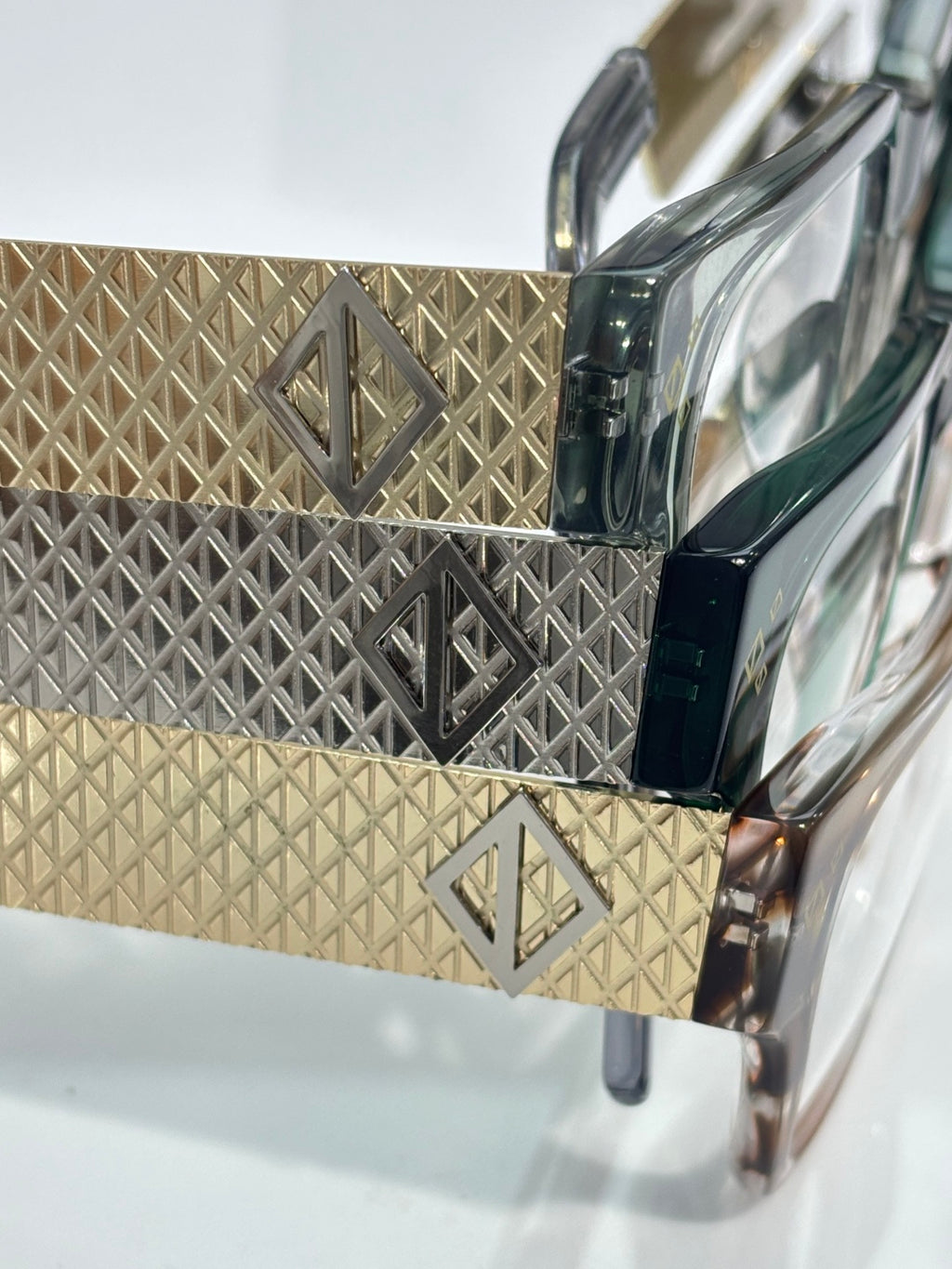 Dior eyeglasses temple close-up with patterned gold and dark inlay