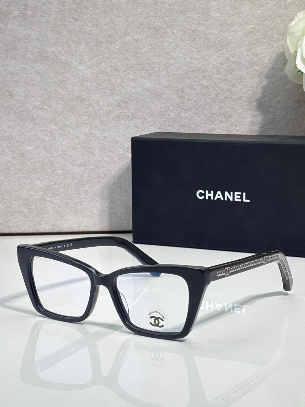Chanel eyeglasses with black rectangular frame and clear lenses, visible temple logo