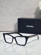 Chanel eyeglasses with black rectangular frame and clear lenses, gold logo on temple