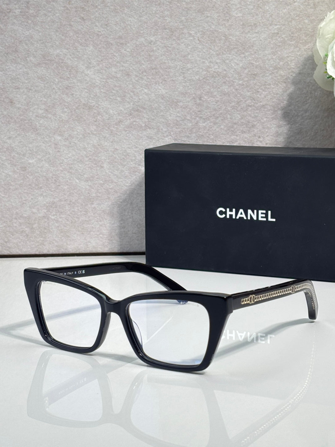 Chanel eyeglasses with black rectangular frame and clear lenses, gold logo on temple