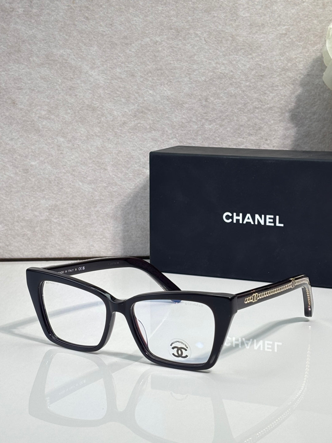 Chanel eyeglasses with black rectangular frame and clear lenses, gold logo on temple