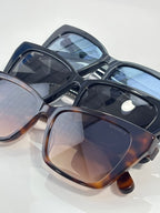 Chanel sunglasses with dark frames and blue-tinted lenses, glossy finish