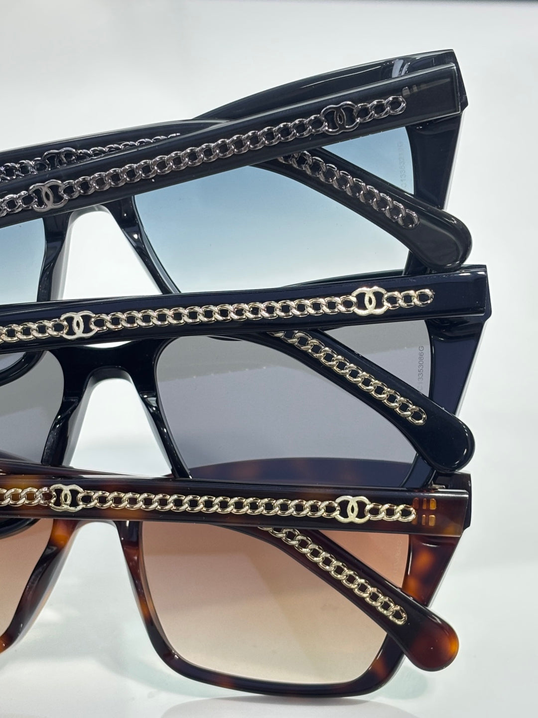 Chanel sunglasses close-up with gold chain-link accents on black and tortoiseshell temples