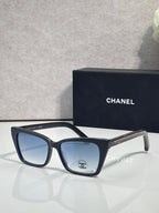 Chanel sunglasses with black acetate frame and blue-tinted lenses, gold temple details