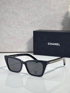 Chanel sunglasses with black acetate frame and dark lenses, curved temple details