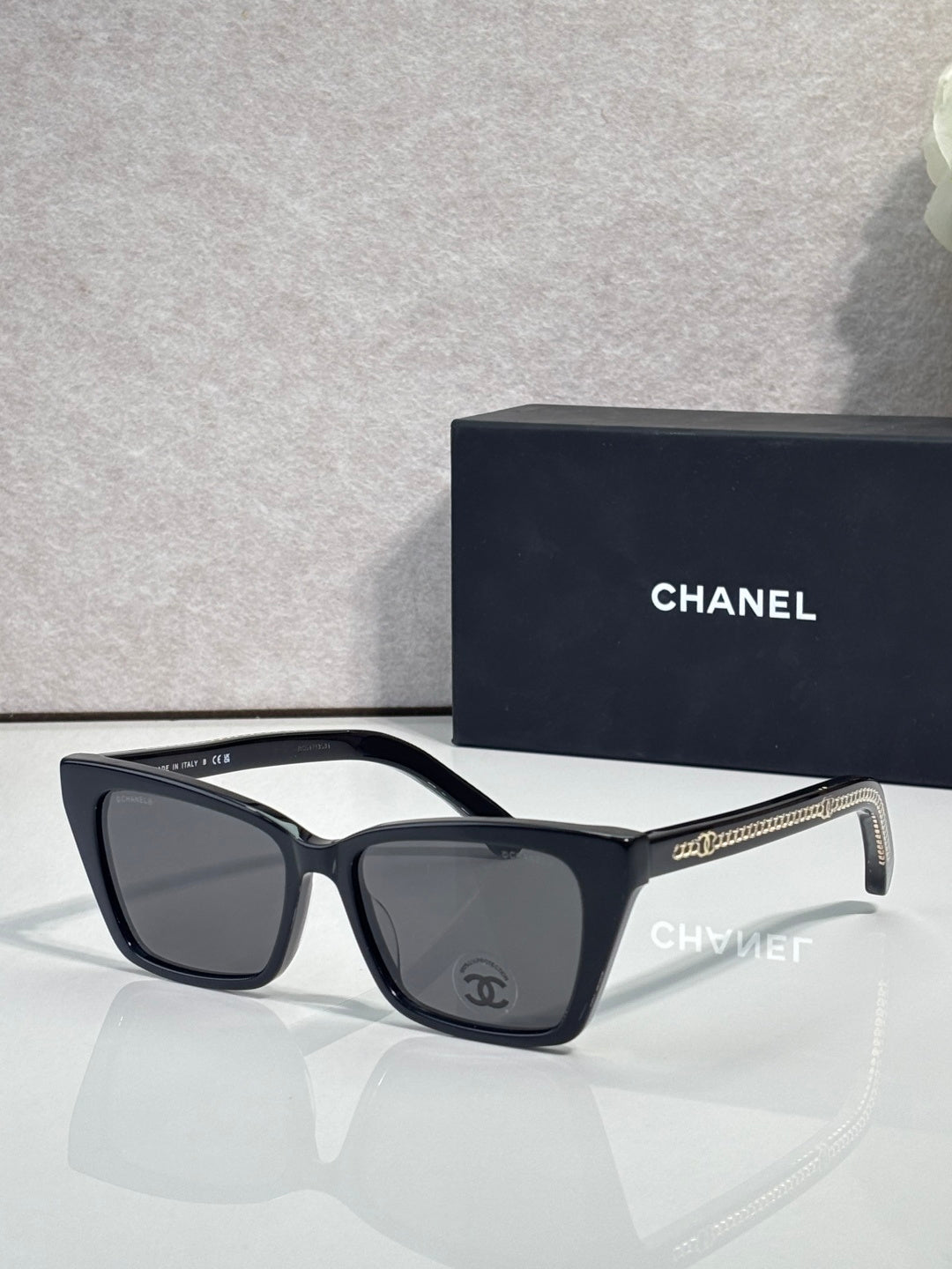 Chanel sunglasses with black acetate frame and dark lenses, curved temple details