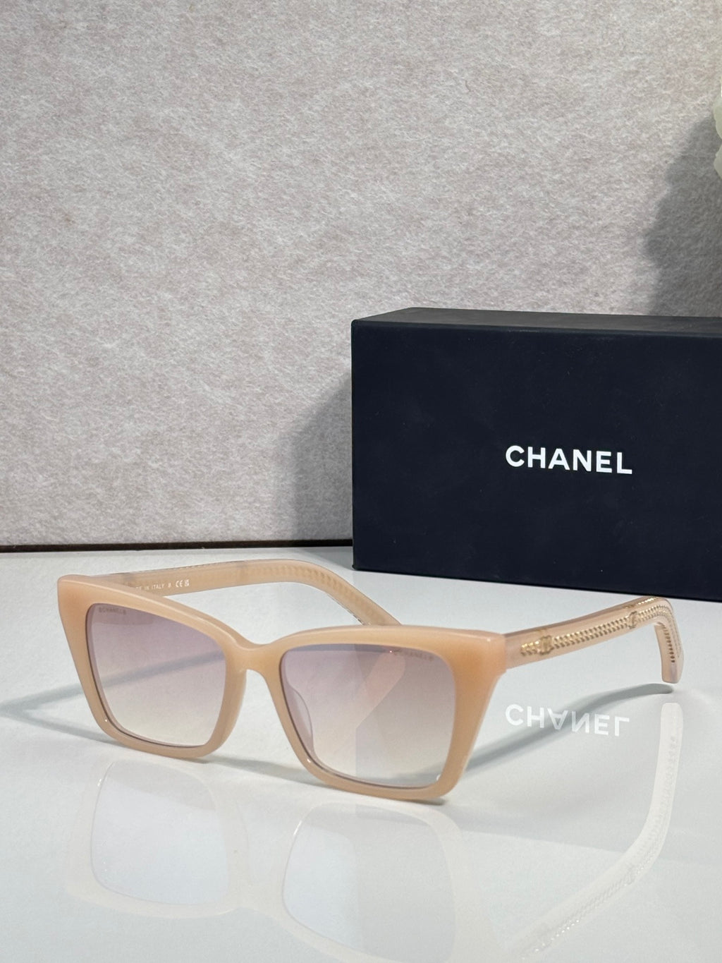 Chanel sunglasses with light tan acetate frame and light lenses, gold logo accents