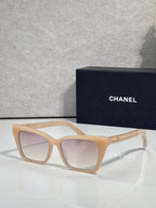 Chanel sunglasses with light tan acetate frame and light lenses, gold logo accents