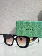 Gucci square sunglasses with dark frames, tinted lenses, and gold GG temple detail