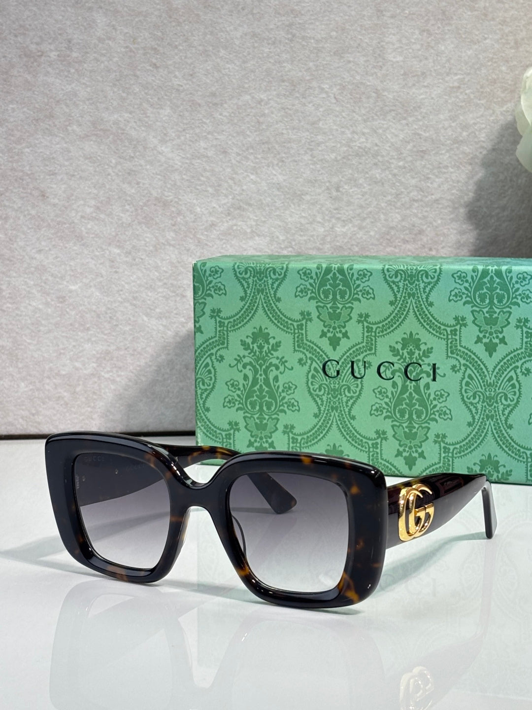 Gucci square sunglasses with dark tortoiseshell frames and tinted lenses, gold GG detail
