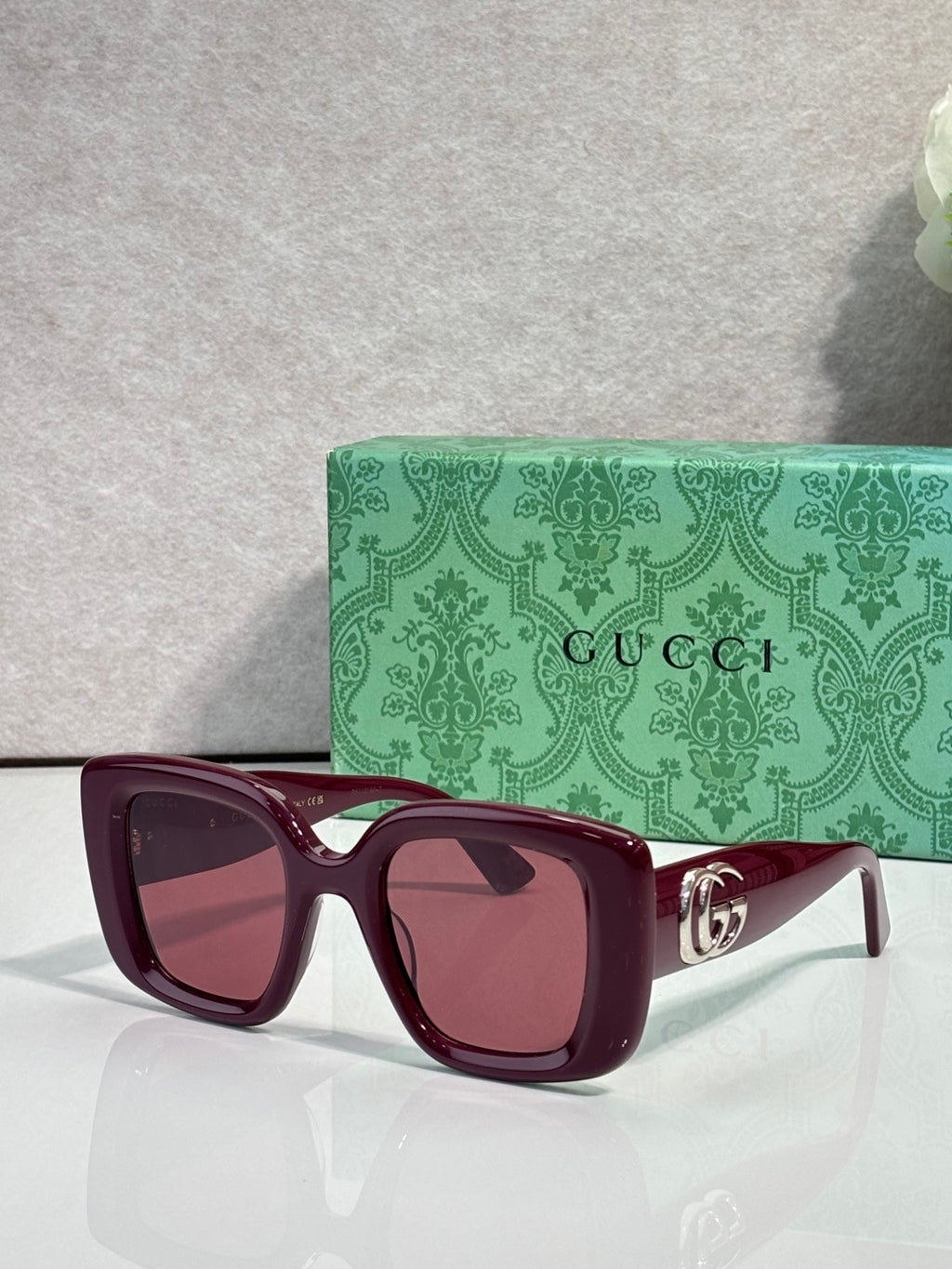 Gucci square sunglasses with burgundy frames, tinted lenses, and gold GG temple detail