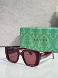 Gucci square sunglasses with burgundy frames, tinted lenses, and gold GG temple detail