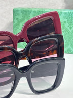 Gucci sunglasses close-up with pink and dark frames, tinted lenses in stacked view