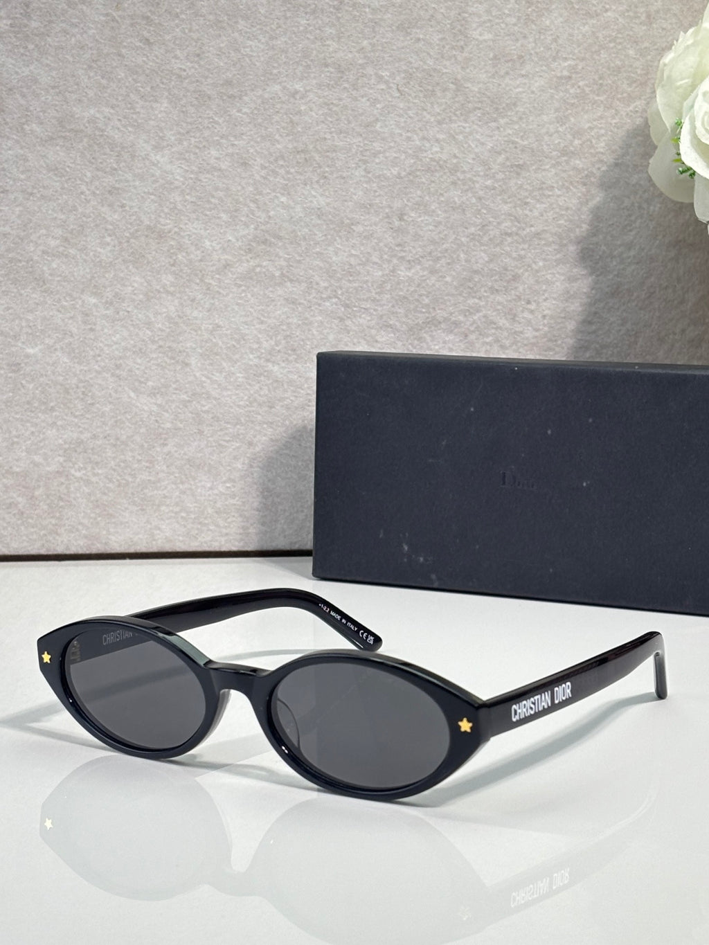 Black Dior glasses with star accents and dark blue round lenses