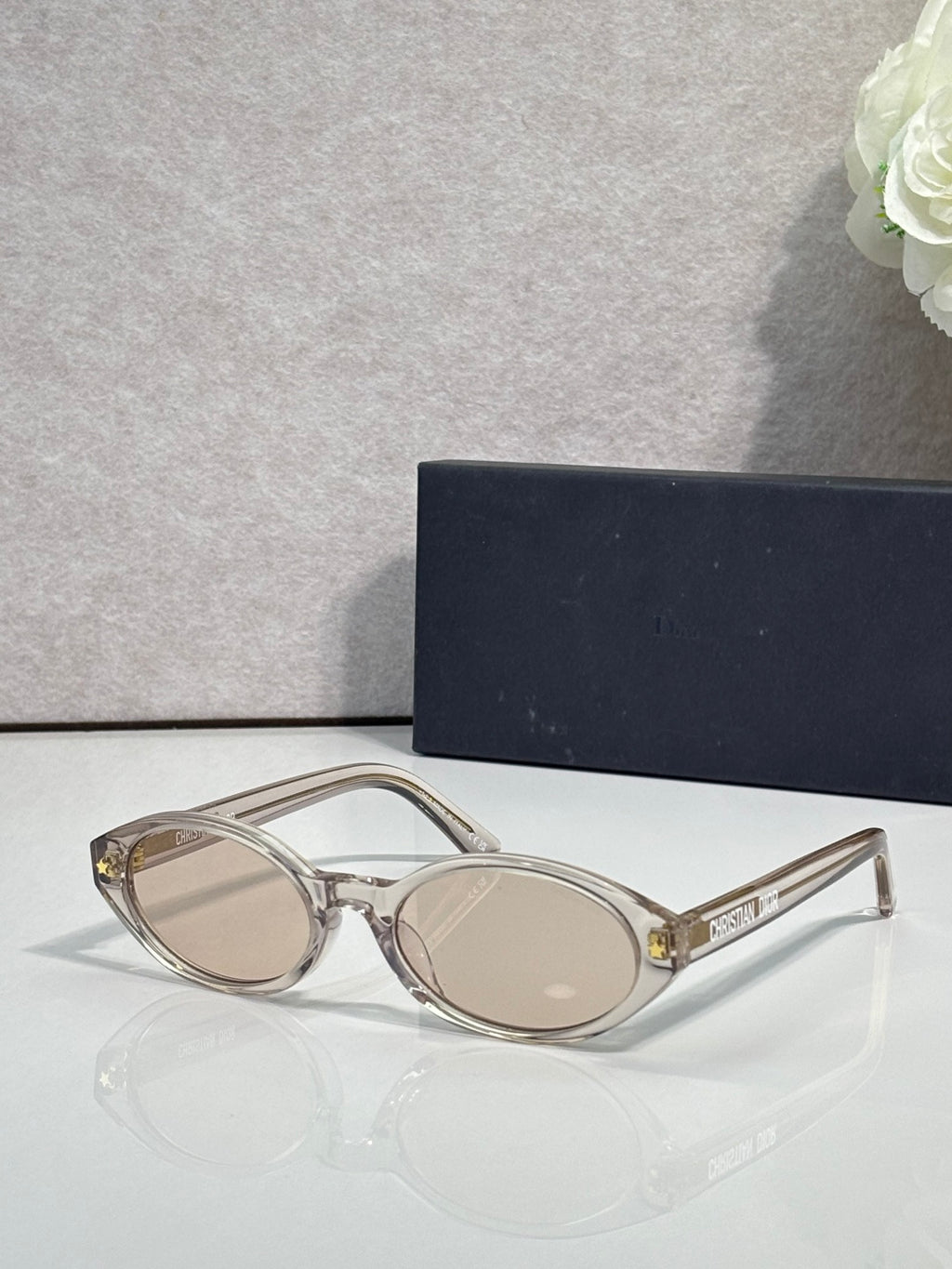 Clear Dior glasses with beige round lenses and gold-tone accents