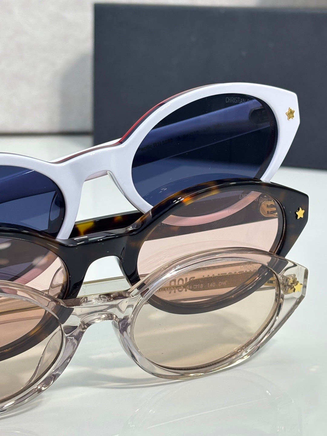 White Dior glasses with navy lenses and star detail on temple