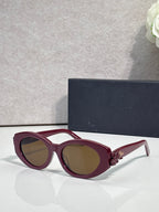 Burgundy round sunglasses with floral temple accents and brown-tinted lenses