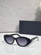 Black oversized round sunglasses with dark-tinted lenses and floral temple detail