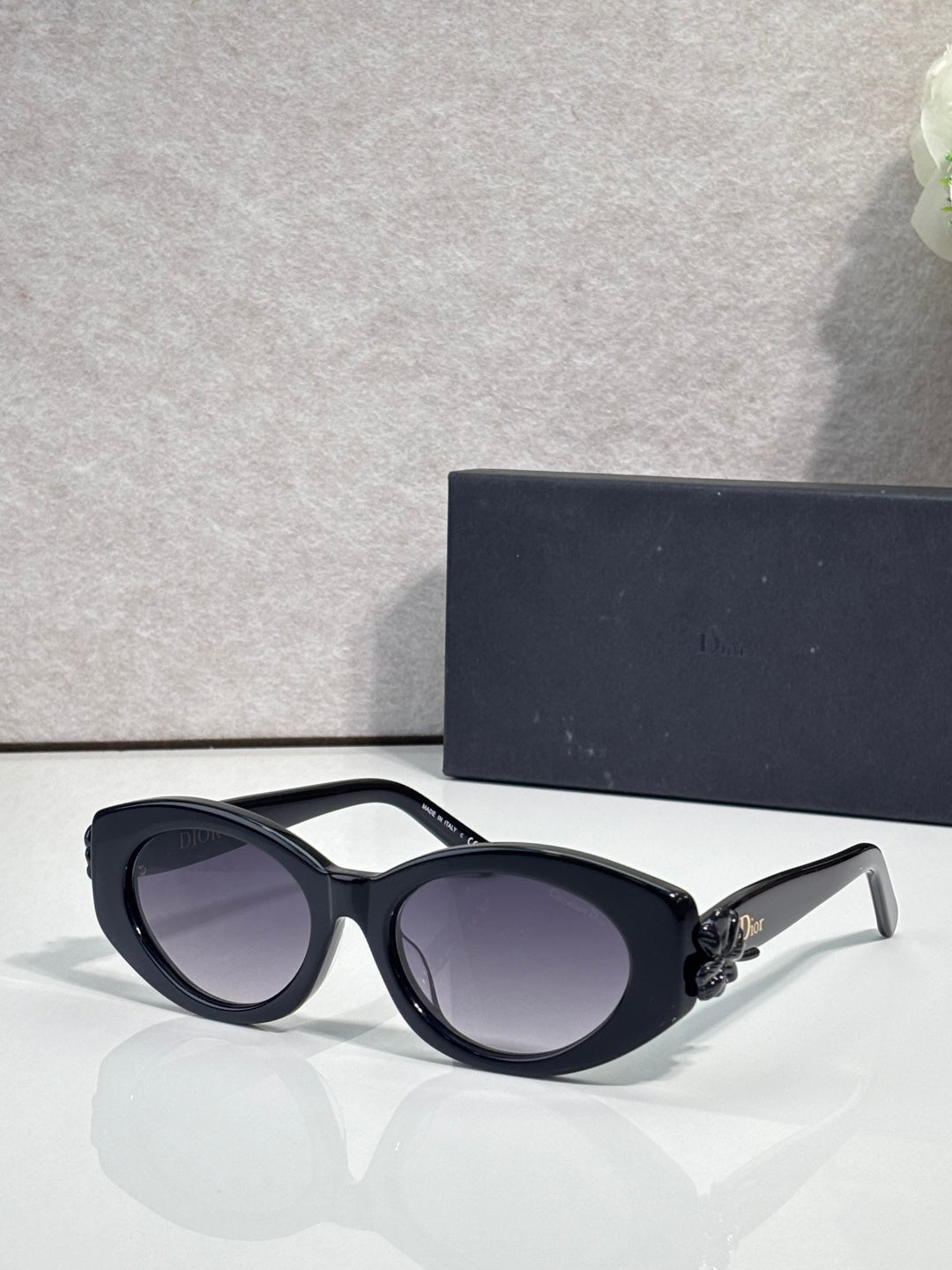 Black oversized round sunglasses with dark-tinted lenses and floral temple detail