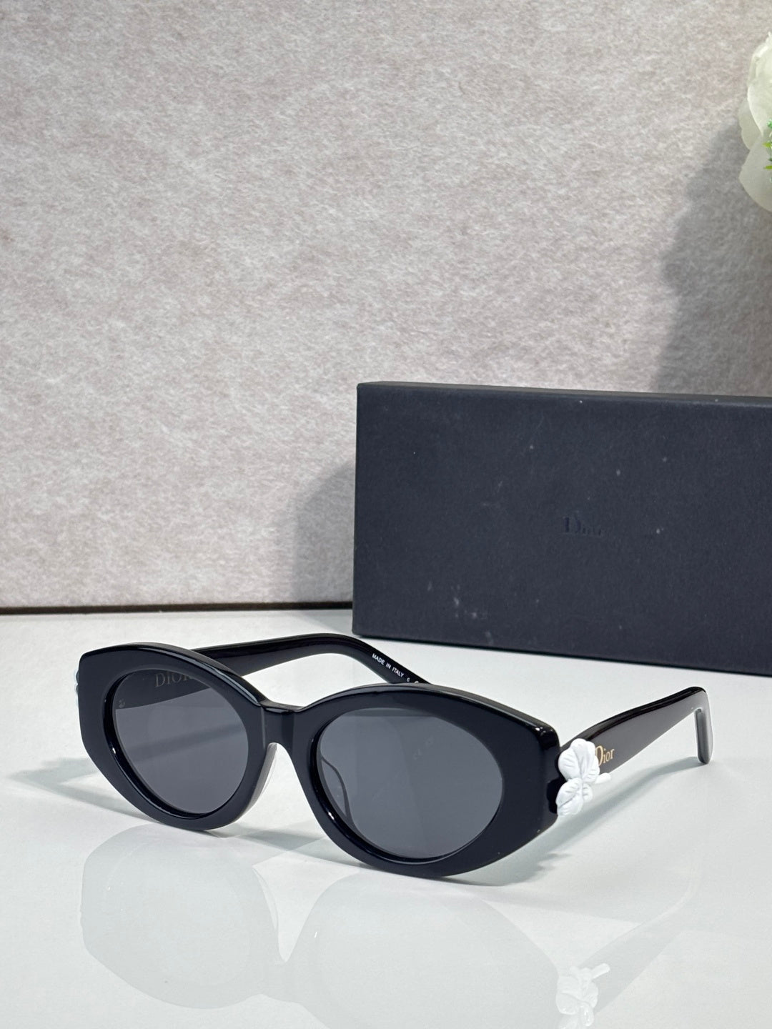 Black round sunglasses with floral temple accents and dark-tinted lenses