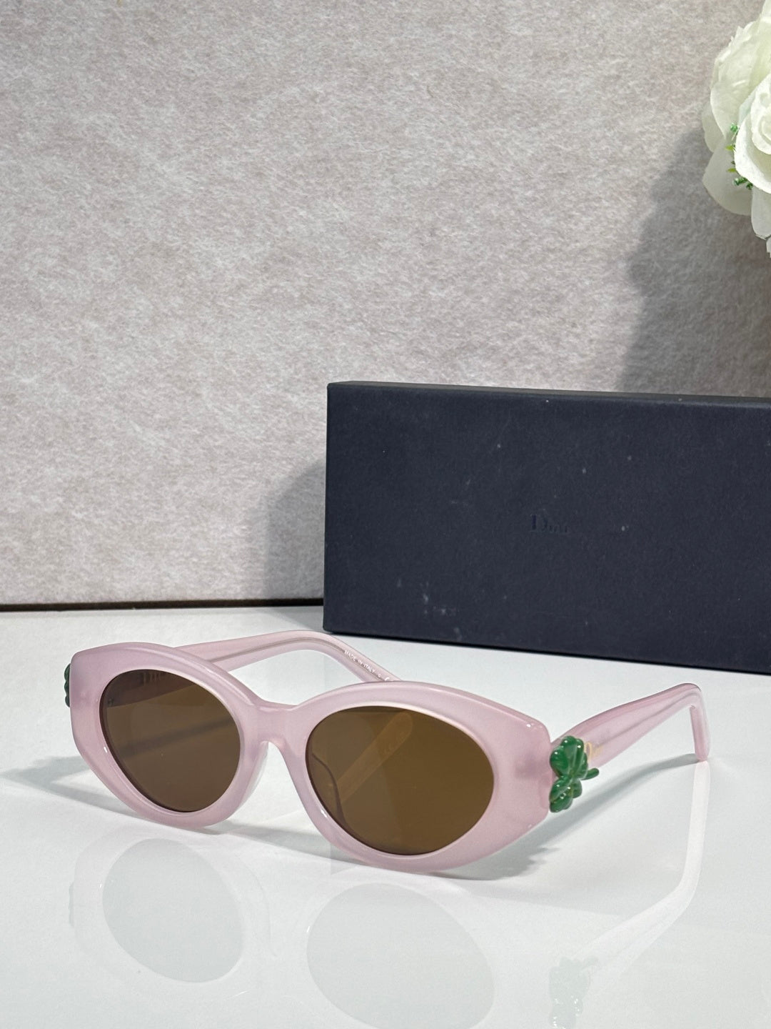 Pink round sunglasses with floral temple accents and brown-tinted lenses