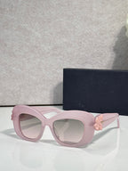 Light pink Dior glasses with rounded square lenses and pink floral charm on the temple.