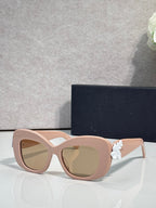 Blush Dior glasses with rounded square lenses and white floral charm on the temple.