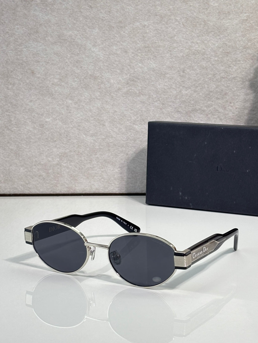 Gold cat-eye sunglasses with dark blue tinted lenses and Dior logo on temple