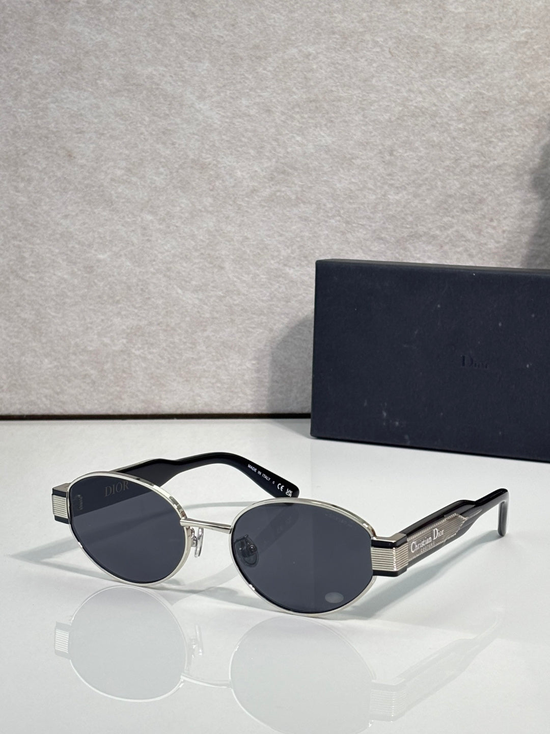 Gold cat-eye sunglasses with dark blue tinted lenses and Dior logo on temple