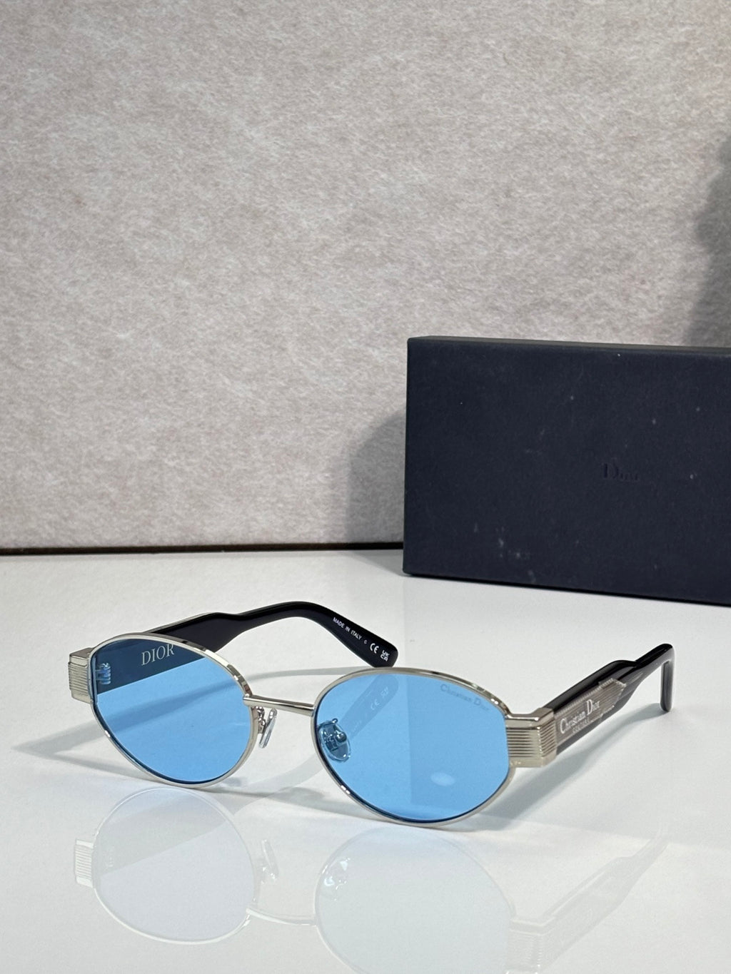 Gold cat-eye sunglasses with light blue tinted lenses and Dior temple branding