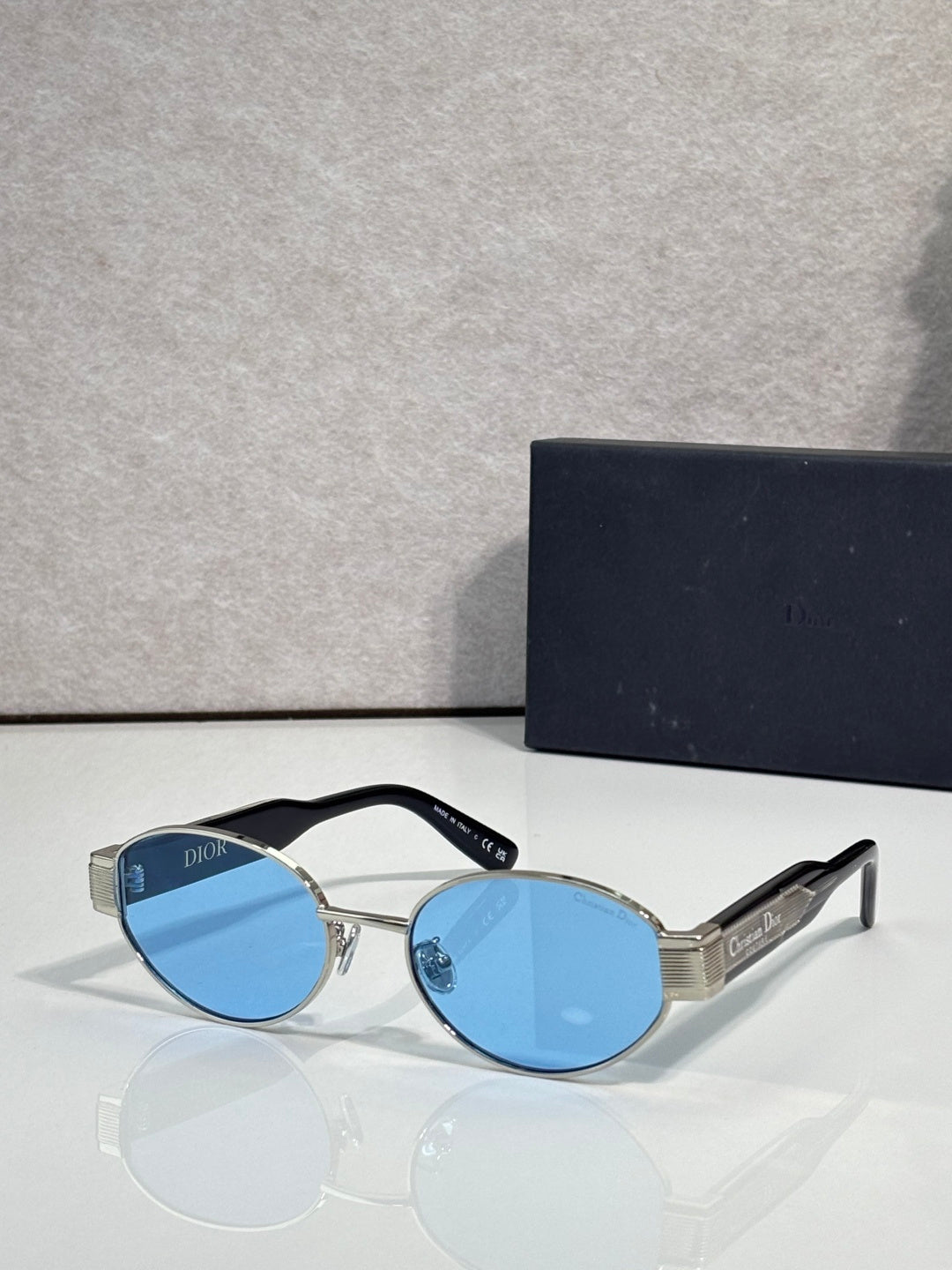 Gold cat-eye sunglasses with light blue tinted lenses and Dior temple branding