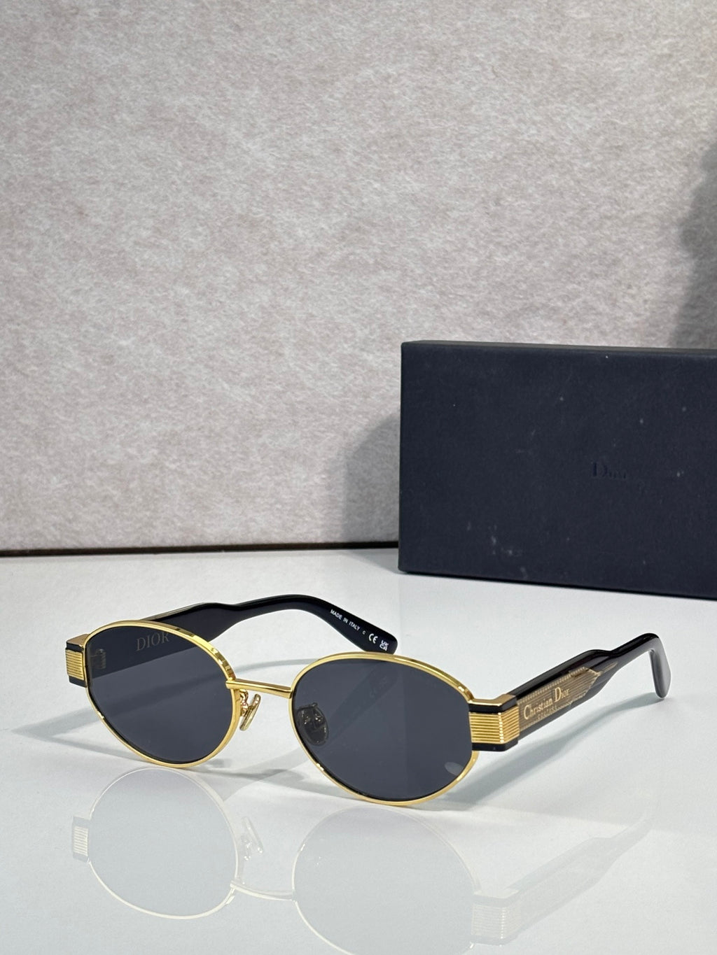 Gold cat-eye sunglasses with dark smoke lenses and Dior logo detail