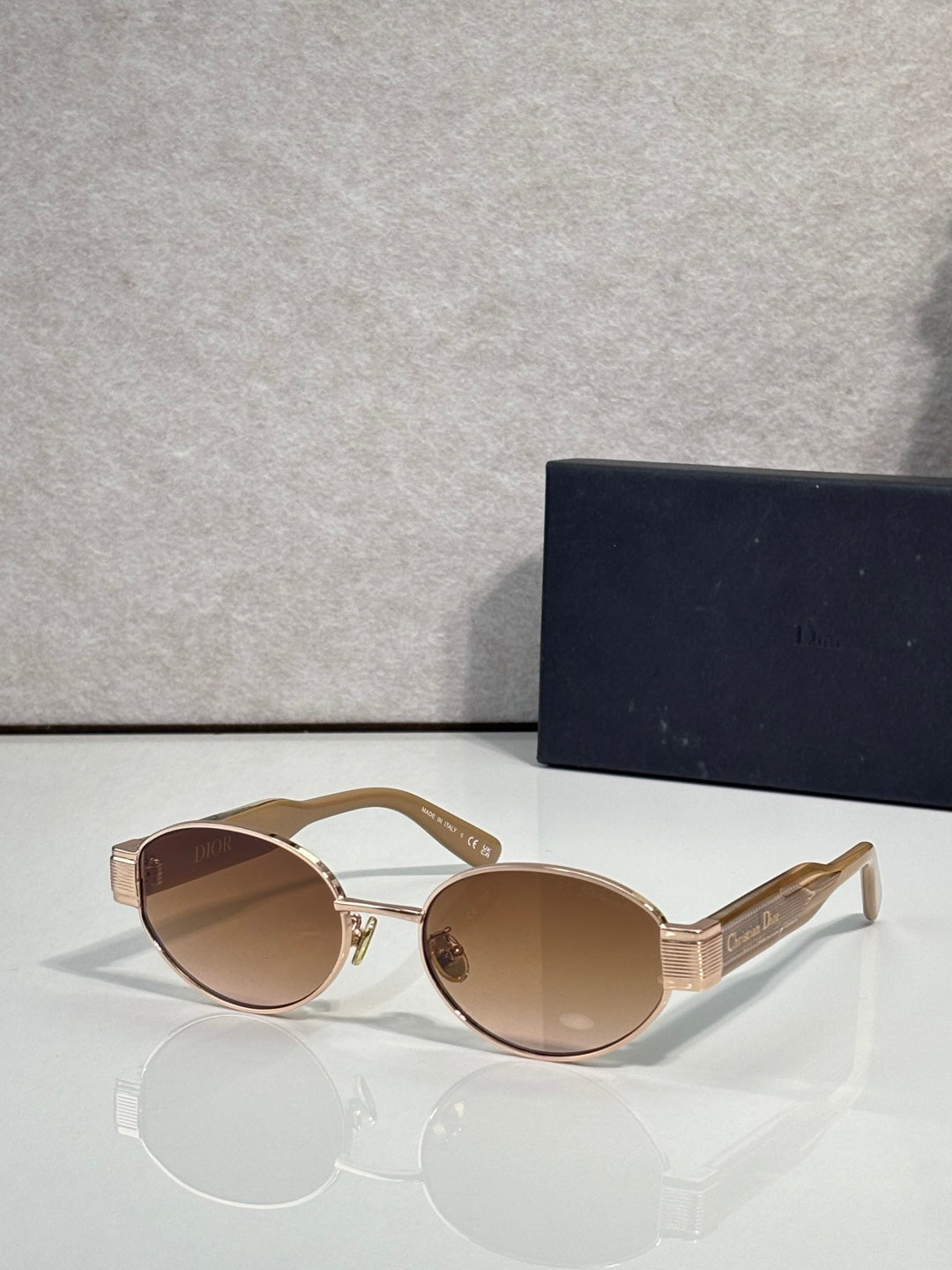 Gold cat-eye sunglasses with warm brown lenses and Dior detailing at temple