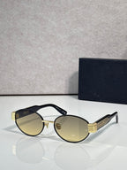 Gold cat-eye sunglasses with amber-tinted lenses and black temple Dior branding