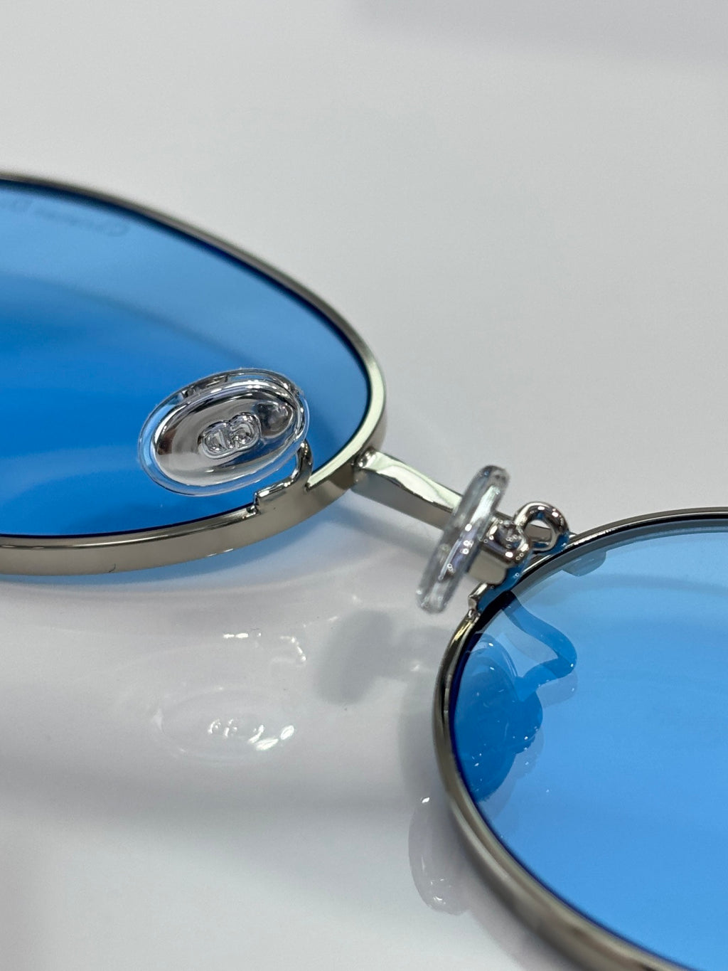 Blue mirrored lens with metal eyeglass hinge and Dior logo detail