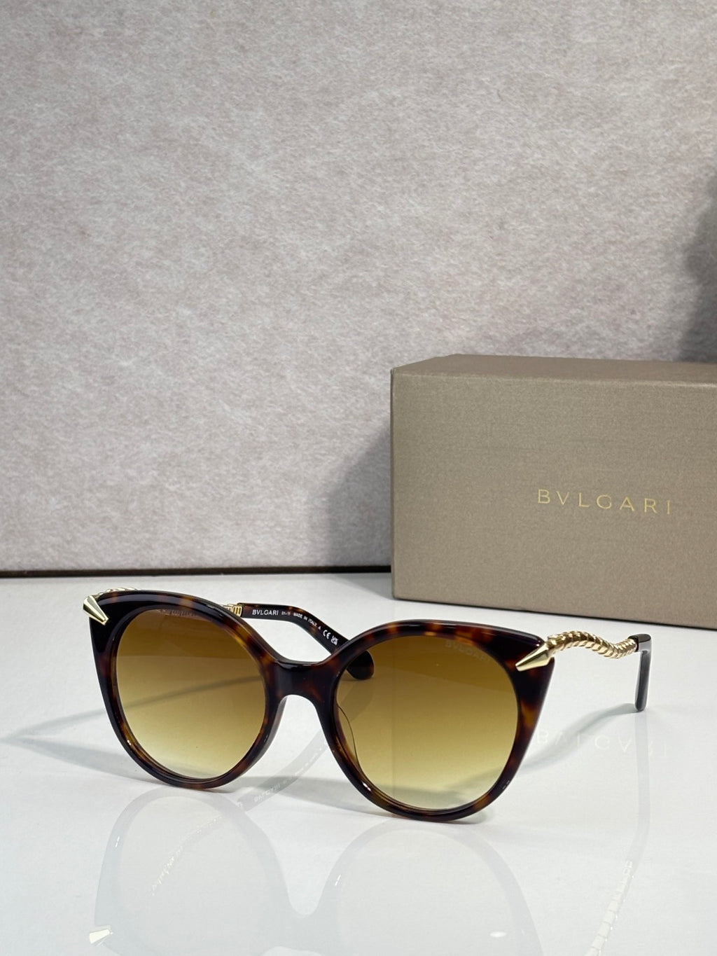 Sunglasses, tortoise-look rounded frames with gold-tone temple tips and amber lenses