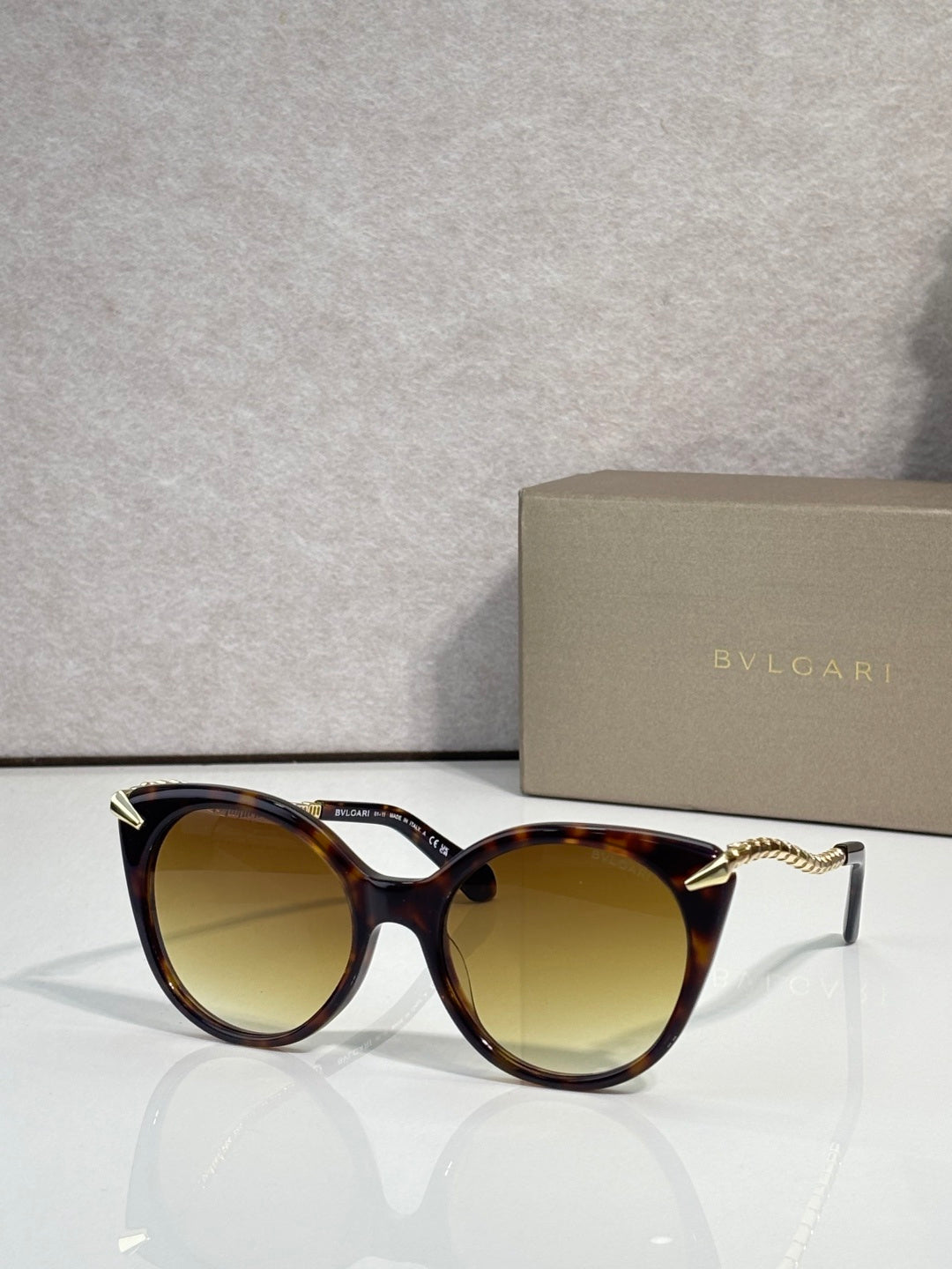 Sunglasses, tortoise-look rounded frames with gold-tone temple tips and amber lenses