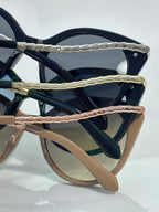 Sunglasses temples in navy, green, and rose tones with gold-tone hinge accents