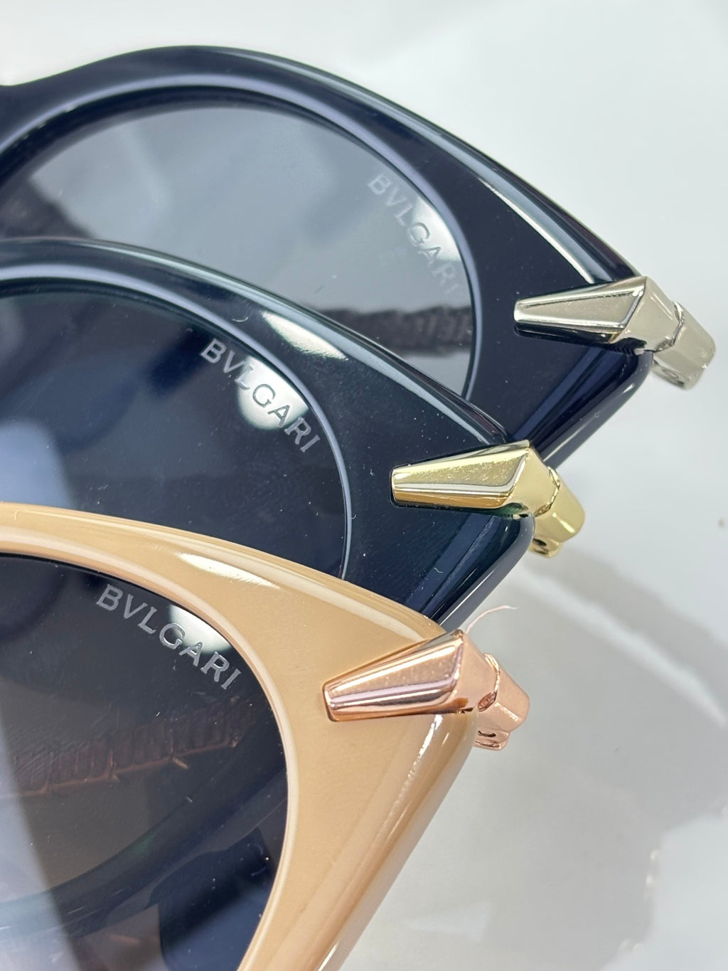 Close-up sunglasses, navy and beige rounded frames with gold-tone details and lenses