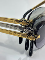 Bvlgari sunglasses close-up: gold logo arms with black frames and snake emblem