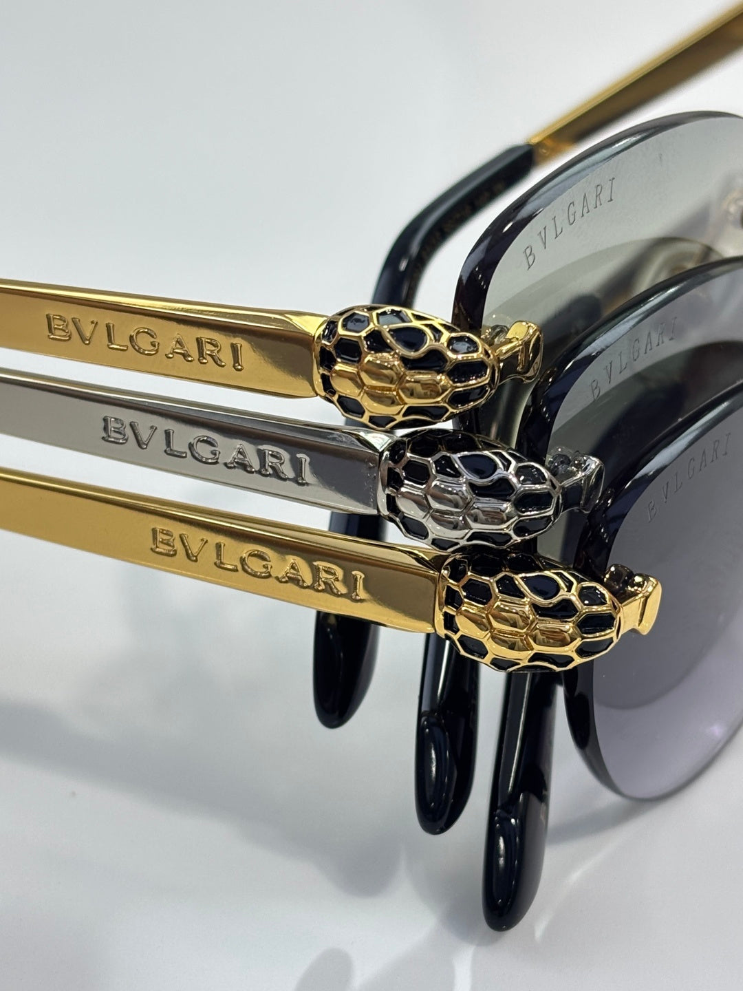 Bvlgari sunglasses close-up: gold logo arms with black frames and snake emblem