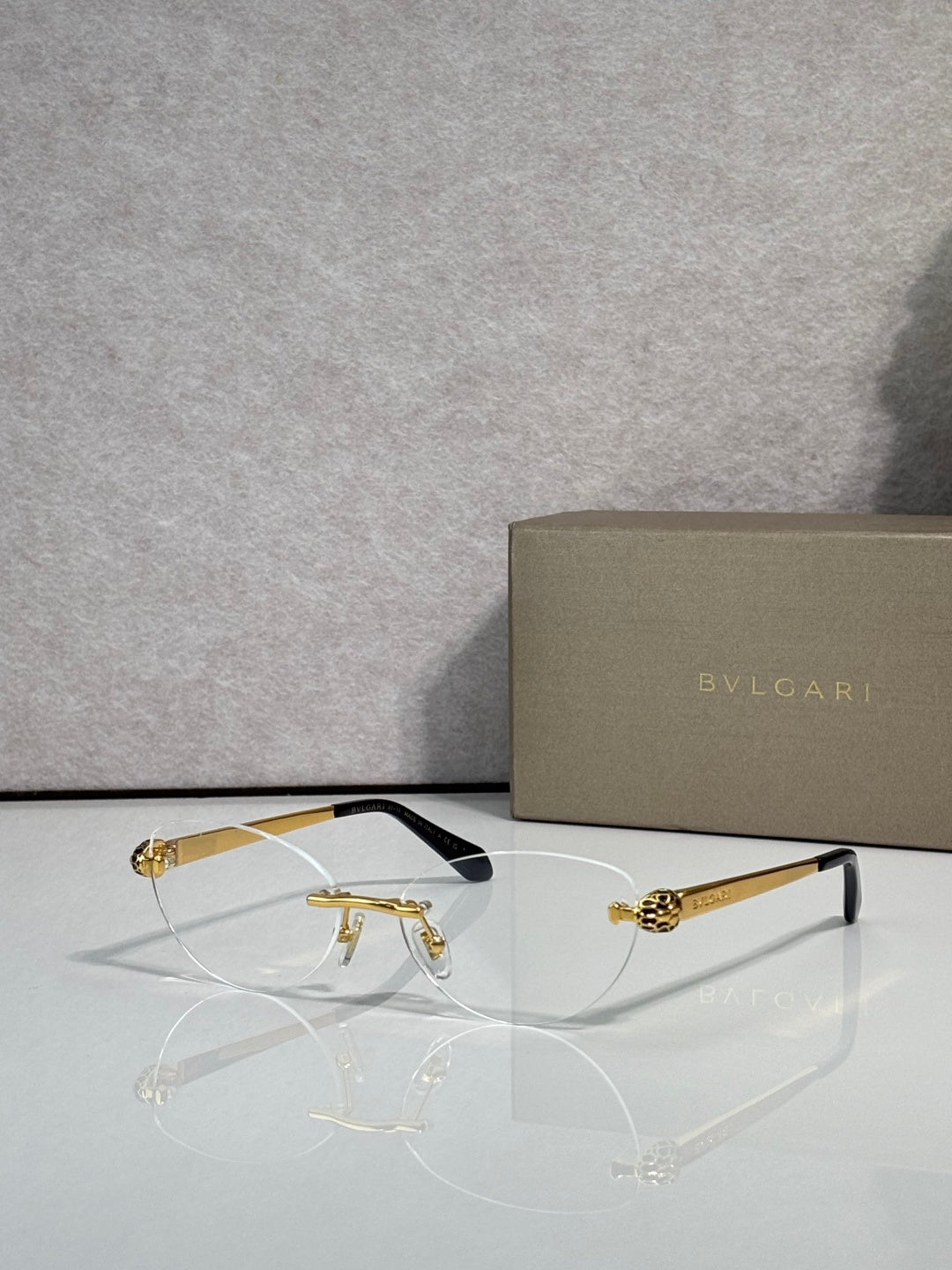 Bvlgari eyeglasses with tinted amber lenses, gold frame and black temple tips
