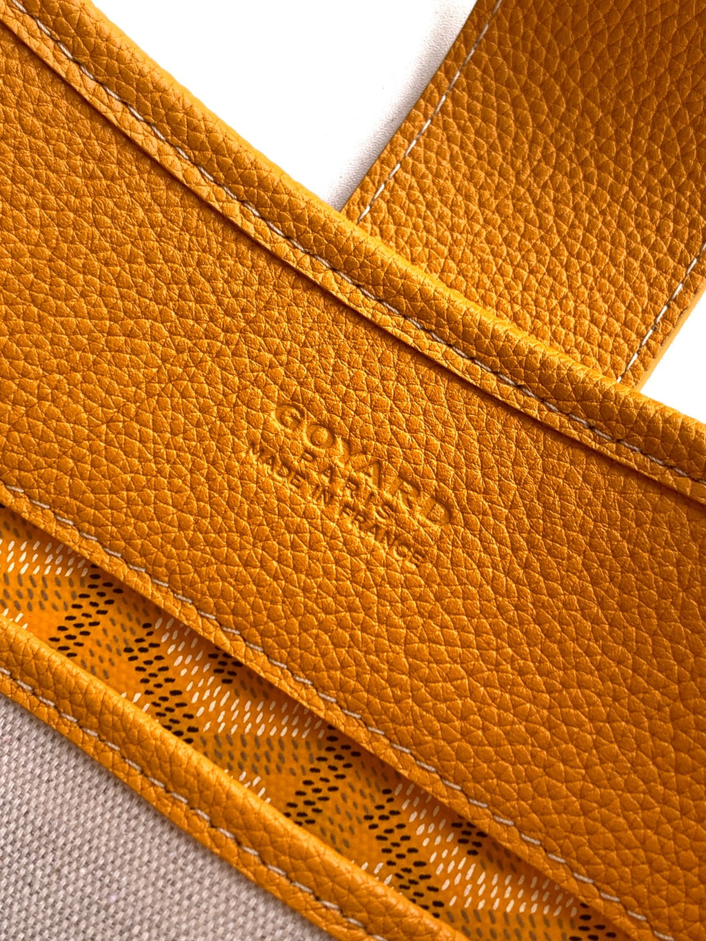 Close-up of mustard leather pocket trim and stitched edge on the bag