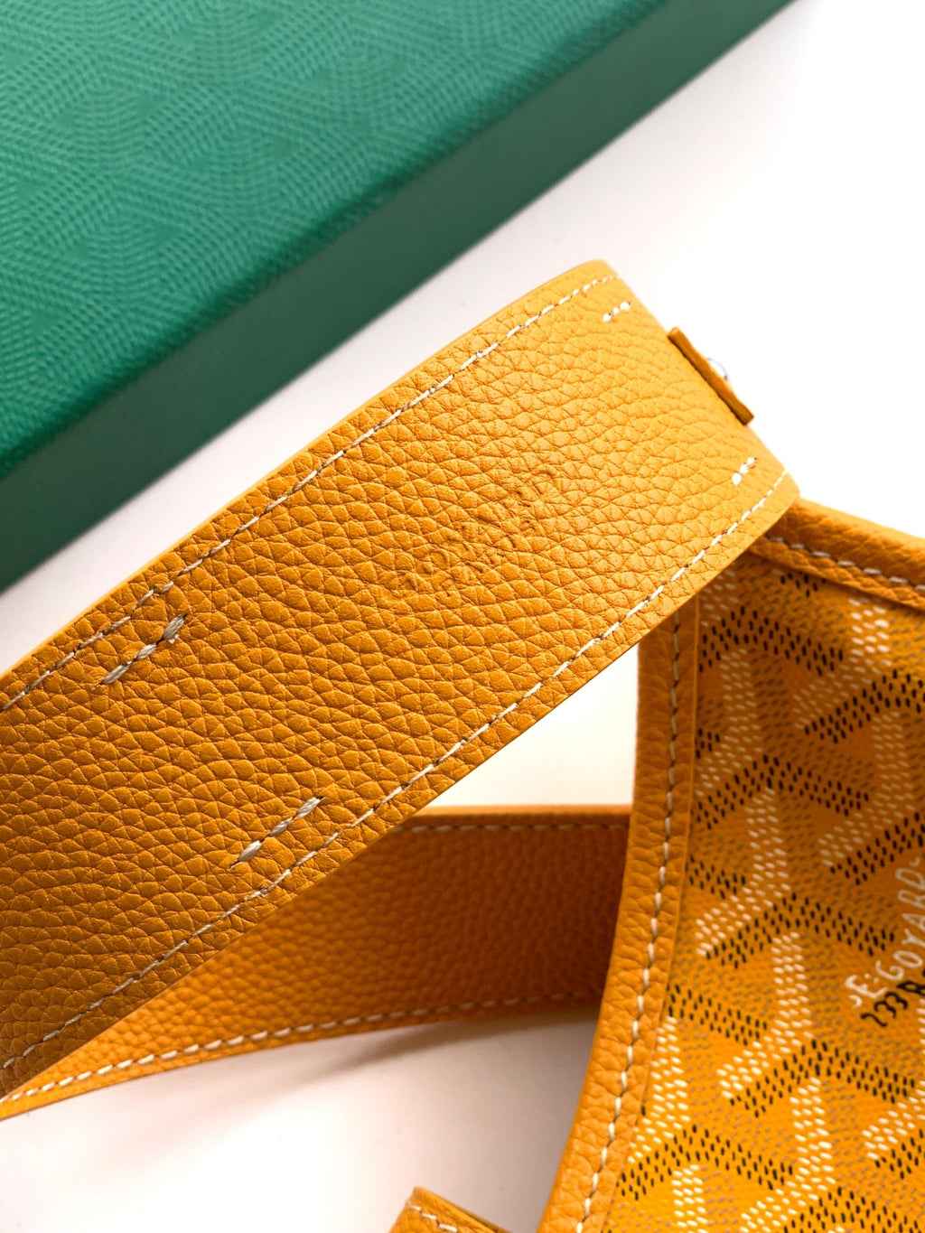Close-up of mustard leather strap holder and monogram canvas side panel